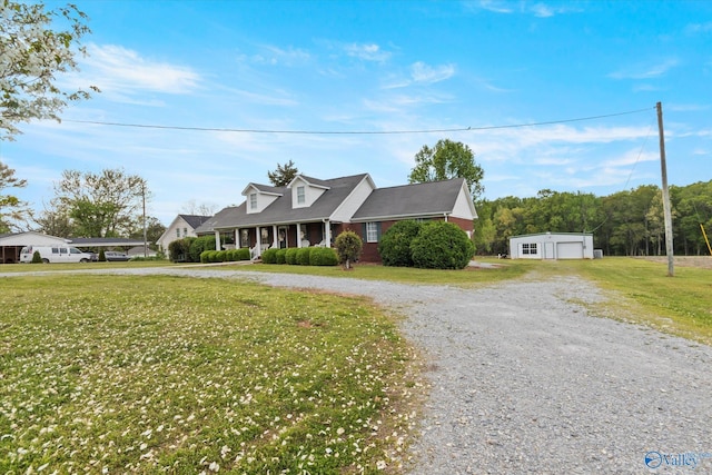 cape cod-style house with a porch, a garage, an outdoor structure, and a front yard