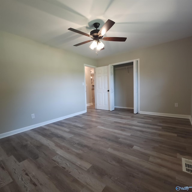 unfurnished bedroom featuring ceiling fan, a closet, and dark hardwood / wood-style flooring