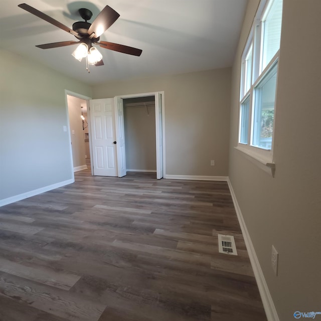 unfurnished bedroom with ceiling fan, a closet, and dark hardwood / wood-style flooring