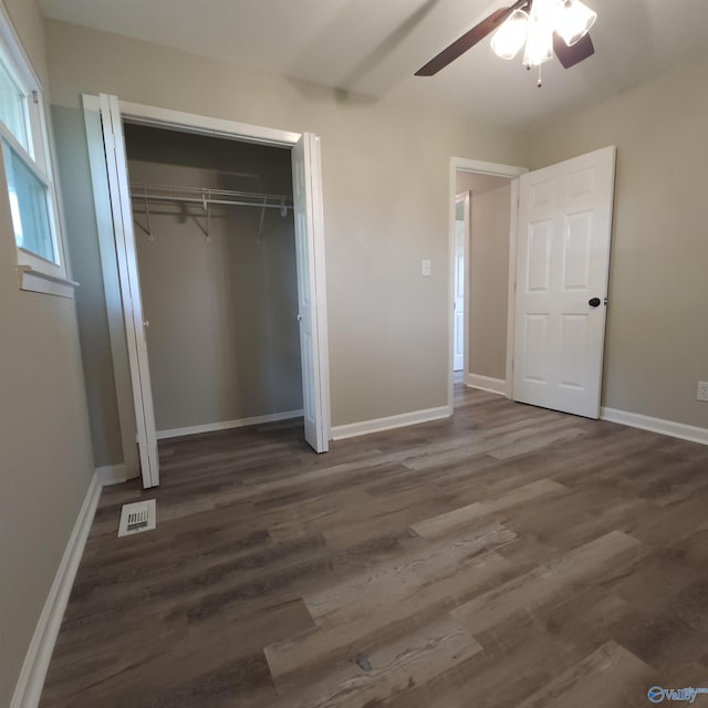 unfurnished bedroom featuring dark wood-type flooring, ceiling fan, and a closet