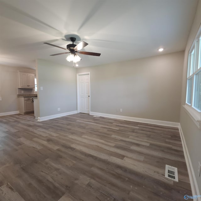 unfurnished living room featuring ceiling fan and dark hardwood / wood-style flooring