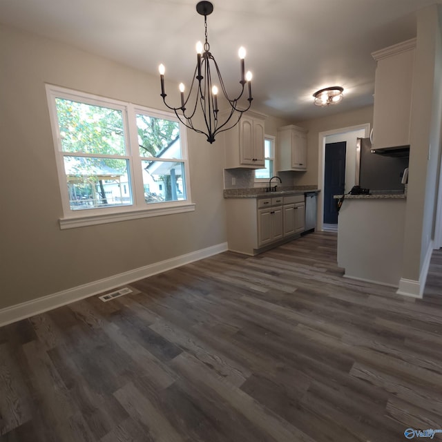 kitchen with dark hardwood / wood-style flooring, an inviting chandelier, appliances with stainless steel finishes, and white cabinets