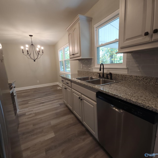 kitchen featuring dark hardwood / wood-style floors, a notable chandelier, stainless steel dishwasher, sink, and decorative backsplash