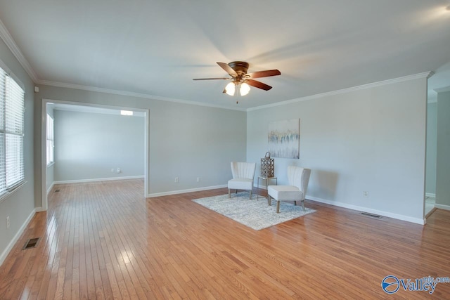 unfurnished room featuring light wood-style flooring, visible vents, baseboards, and ornamental molding