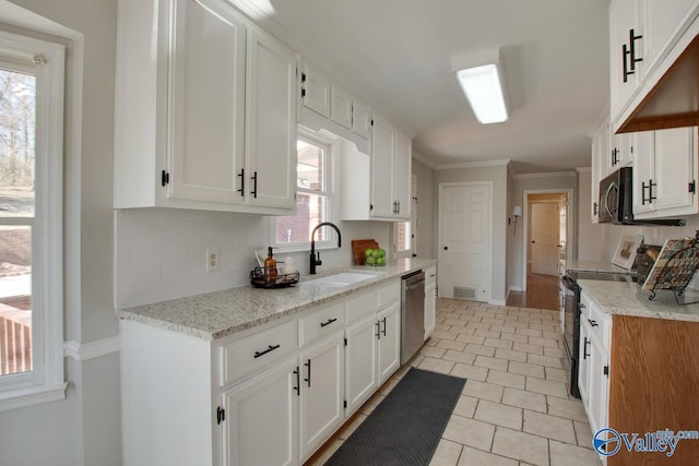 kitchen featuring tasteful backsplash, appliances with stainless steel finishes, white cabinets, and a sink