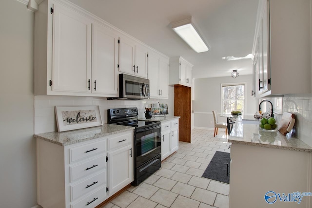 kitchen featuring tasteful backsplash, stainless steel microwave, white cabinetry, a sink, and black / electric stove