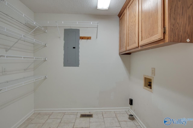 laundry area featuring washer hookup, cabinet space, a textured ceiling, electric panel, and baseboards