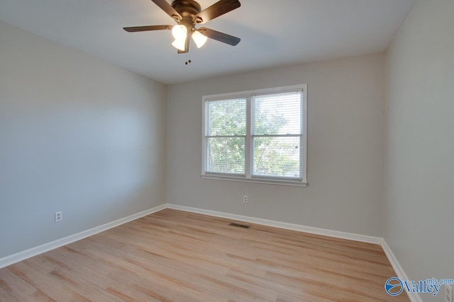 empty room with baseboards, a ceiling fan, visible vents, and light wood-style floors