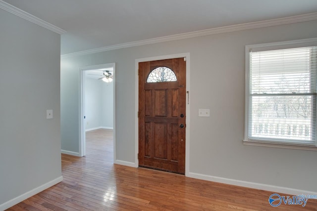 entryway with a healthy amount of sunlight, baseboards, ornamental molding, and hardwood / wood-style floors