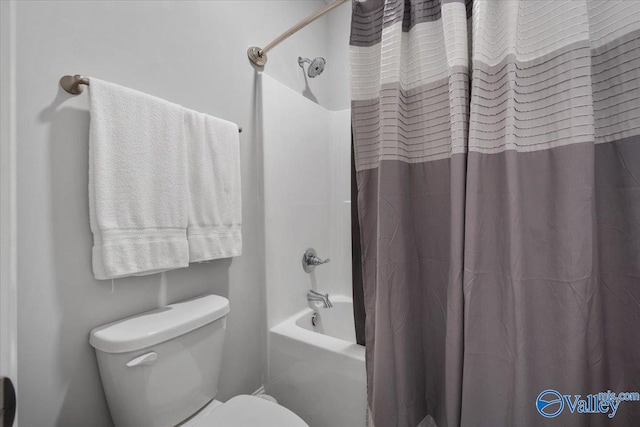 bathroom featuring toilet and shower / tub combo with curtain