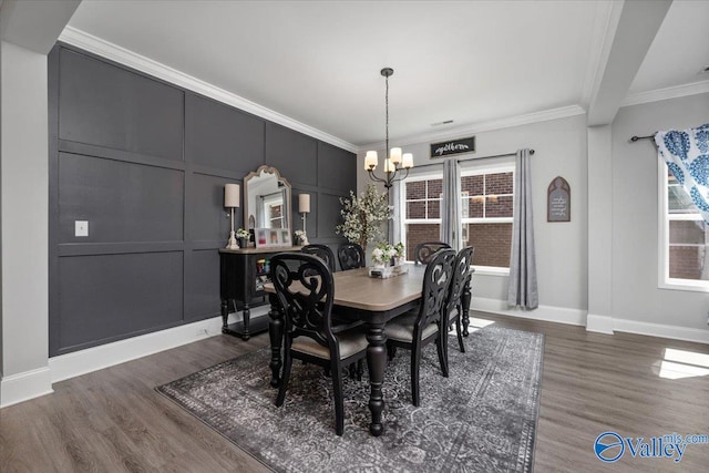 dining area featuring dark hardwood / wood-style floors, ornamental molding, and a chandelier