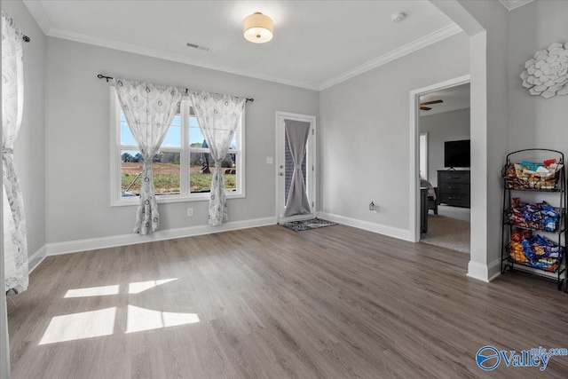 interior space with crown molding, hardwood / wood-style floors, and ceiling fan