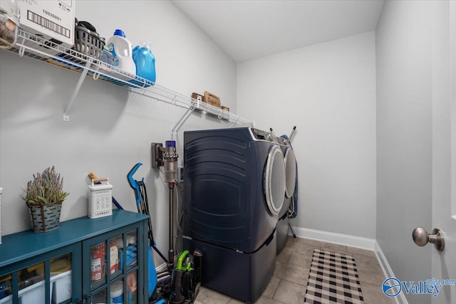 laundry area with light tile patterned floors and washing machine and clothes dryer