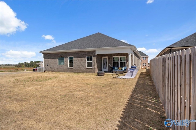 rear view of property featuring a yard and an outdoor fire pit