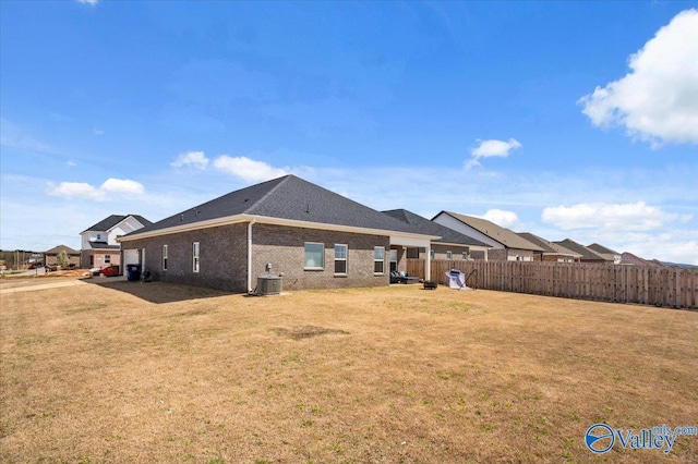 rear view of house featuring a yard and central AC