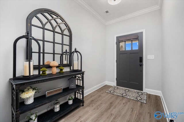 entrance foyer with crown molding and hardwood / wood-style floors