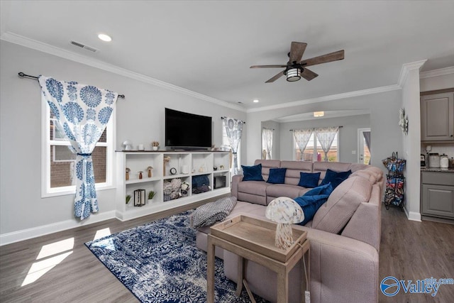 living room featuring dark hardwood / wood-style floors, ceiling fan, and crown molding