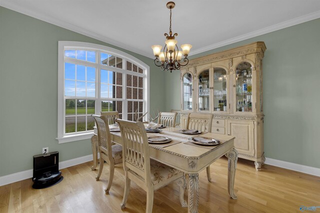 dining area with light hardwood / wood-style floors, a notable chandelier, and ornamental molding