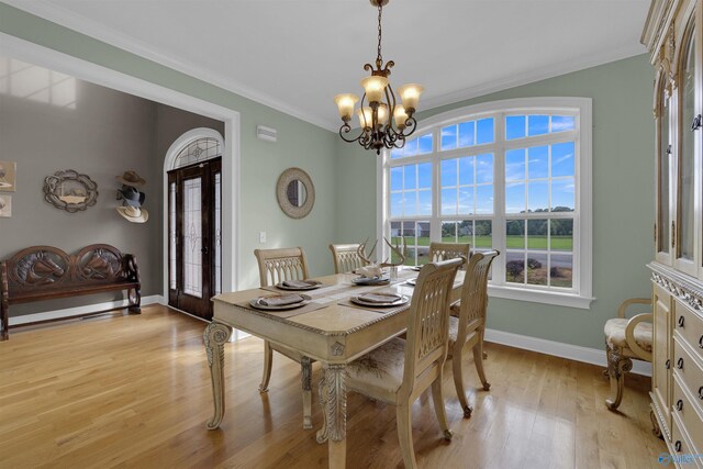 dining room featuring a chandelier, ornamental molding, and light hardwood / wood-style floors