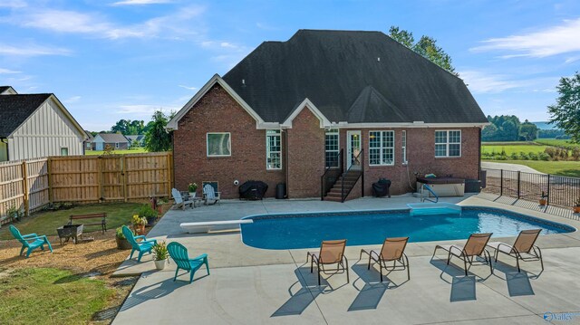 view of pool with a patio and a diving board