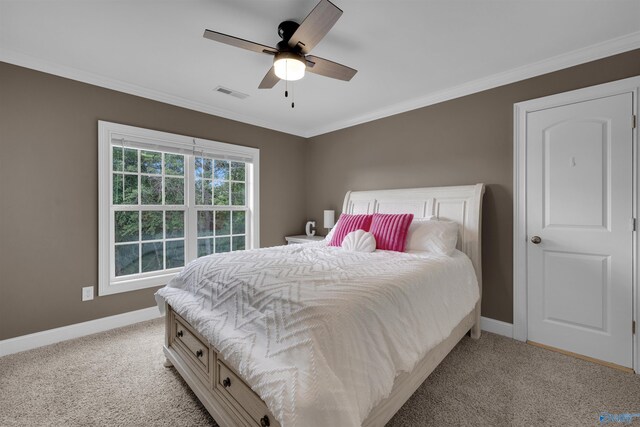 carpeted bedroom with ornamental molding and ceiling fan