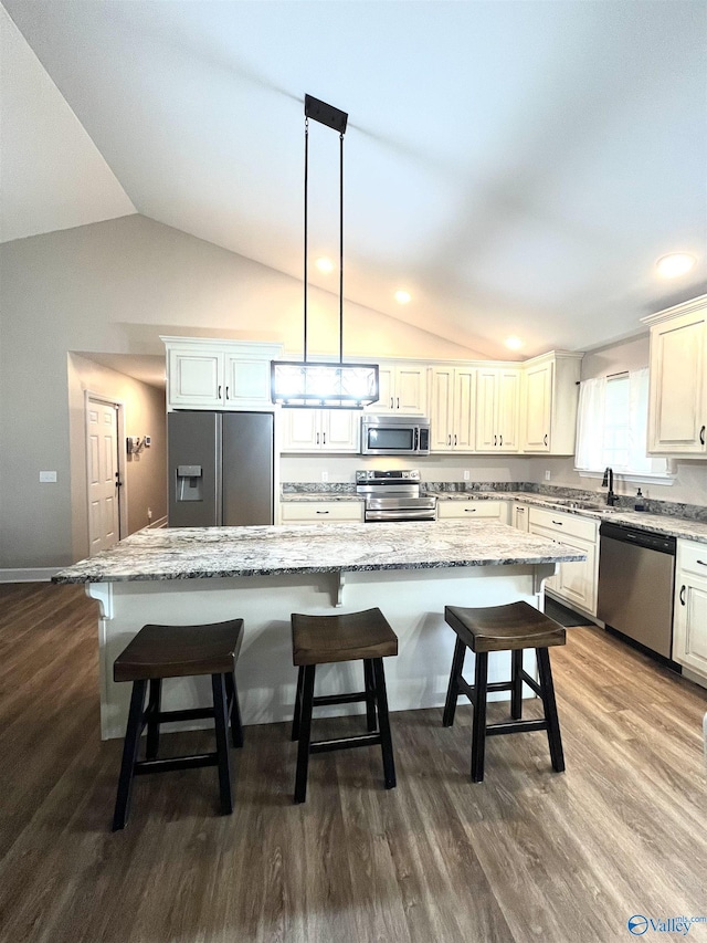 122 Taylor Ridge Rd, Leesburg, AL 35983 - kitchen featuring appliances with stainless steel finishes, lofted ceiling, a kitchen island, dark wood-style floors, and a kitchen bar