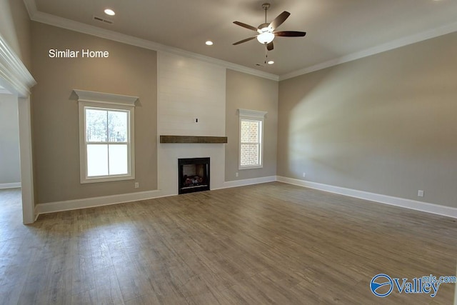 unfurnished living room featuring wood finished floors, plenty of natural light, a ceiling fan, and visible vents