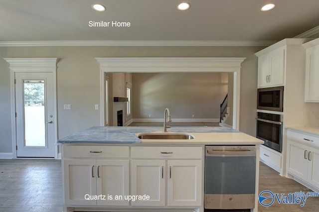 kitchen with white cabinetry, stainless steel appliances, crown molding, and a sink