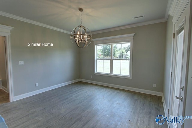 spare room with visible vents, ornamental molding, wood finished floors, baseboards, and a chandelier