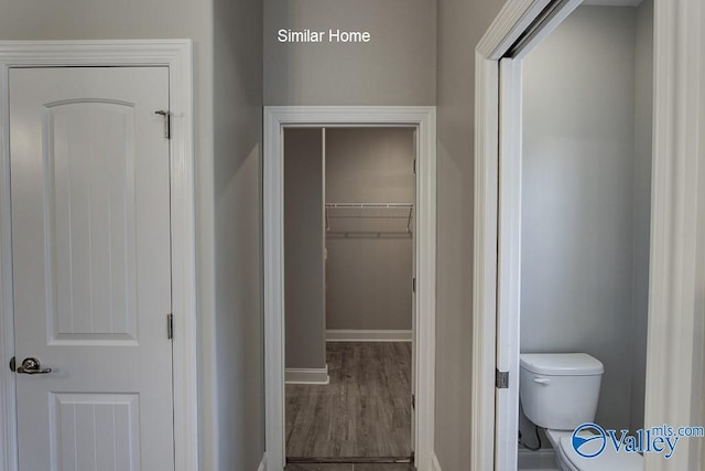 bathroom featuring a closet, baseboards, toilet, and wood finished floors