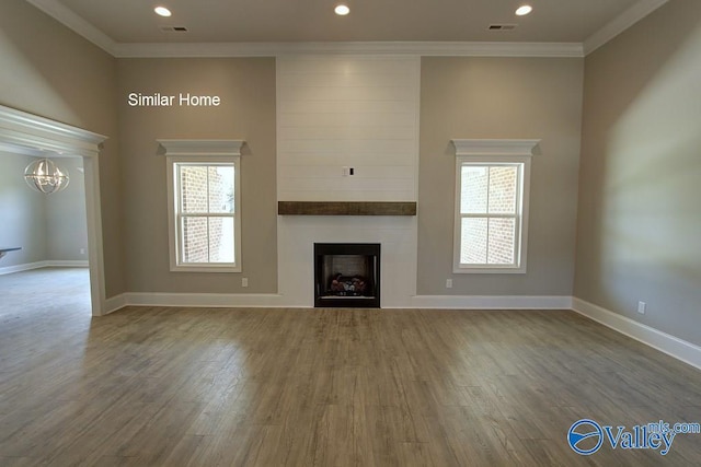 unfurnished living room featuring visible vents, plenty of natural light, ornamental molding, and a fireplace