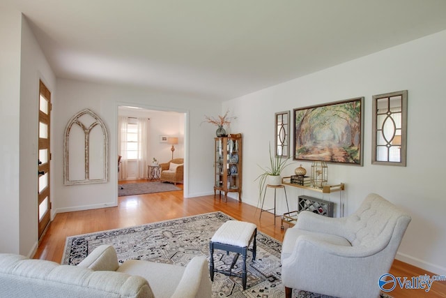 living area with baseboards and wood finished floors