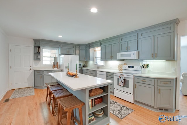 kitchen with light wood-type flooring, open shelves, white appliances, and tasteful backsplash