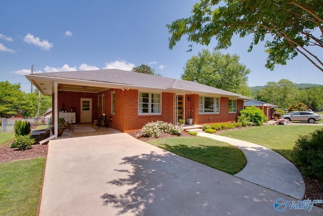 single story home featuring brick siding, fence, a front yard, and concrete driveway
