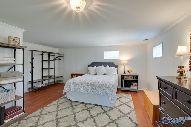 bedroom featuring crown molding, visible vents, and wood finished floors