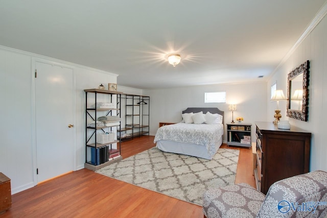 bedroom with crown molding and wood finished floors