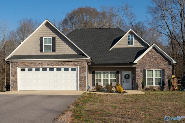 craftsman-style home with a front lawn, aphalt driveway, stone siding, roof with shingles, and a garage