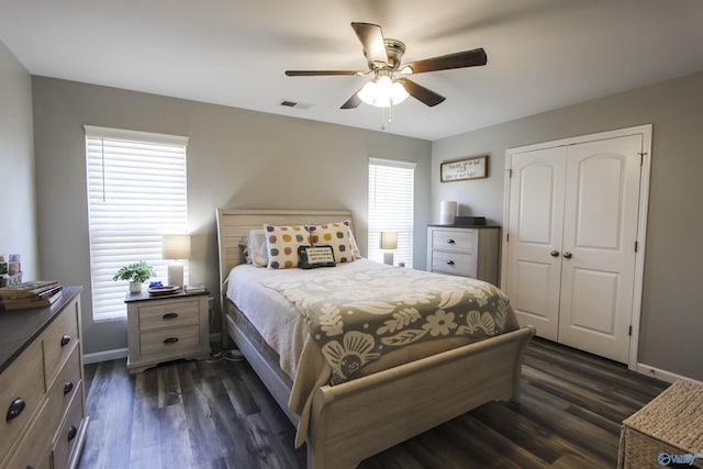 bedroom with a closet, baseboards, and dark wood-style floors