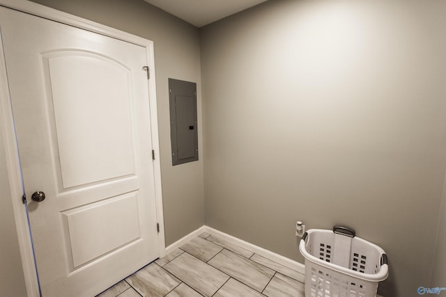 clothes washing area featuring electric panel and baseboards