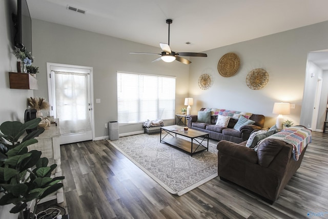 living area with visible vents, baseboards, dark wood-style floors, and a ceiling fan