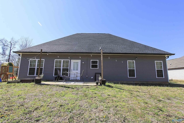 back of property featuring a patio, a playground, a lawn, and roof with shingles