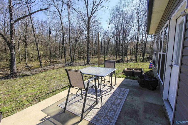 view of patio / terrace with a forest view and outdoor dining area