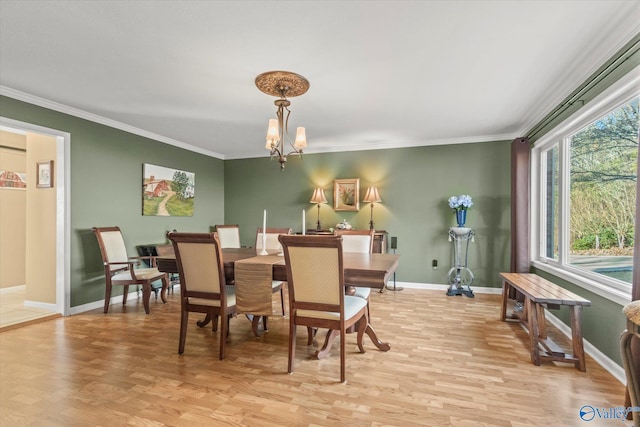 dining room with crown molding, light hardwood / wood-style floors, and a notable chandelier