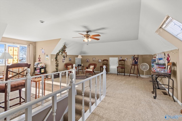 interior space with vaulted ceiling, carpet, and ceiling fan