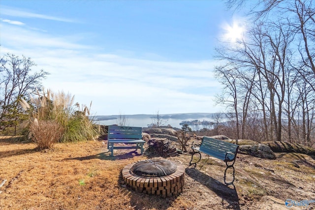 view of yard featuring a fire pit and a water view