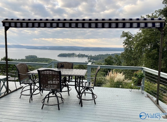 wooden deck with a water and mountain view