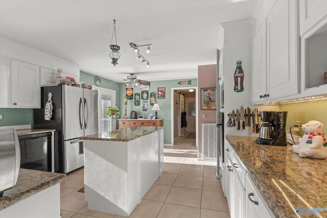 kitchen with stainless steel fridge, ceiling fan, white cabinets, light tile patterned flooring, and dark stone countertops