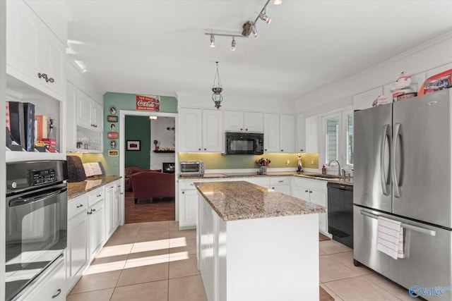 kitchen with white cabinetry, black appliances, stone counters, and a kitchen island