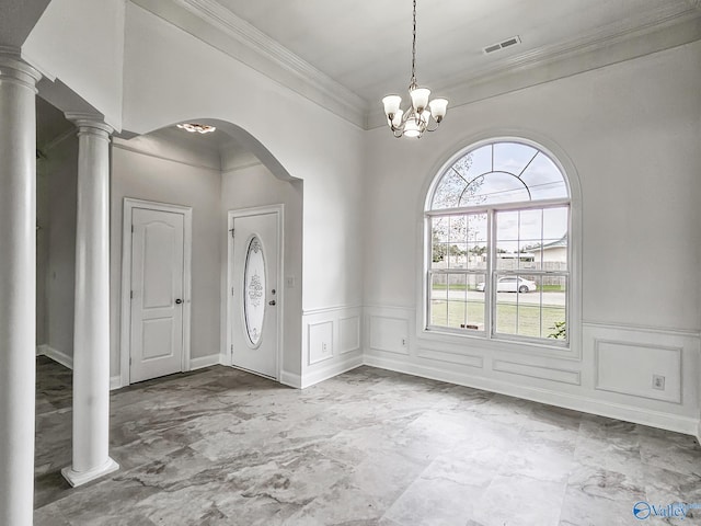 foyer with decorative columns, ornamental molding, and an inviting chandelier