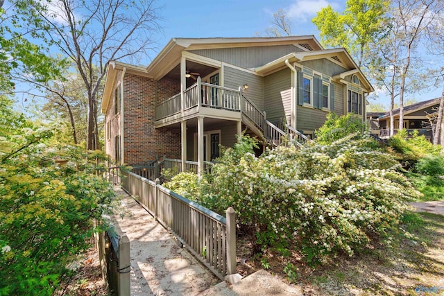 back of property featuring stairs and a ceiling fan